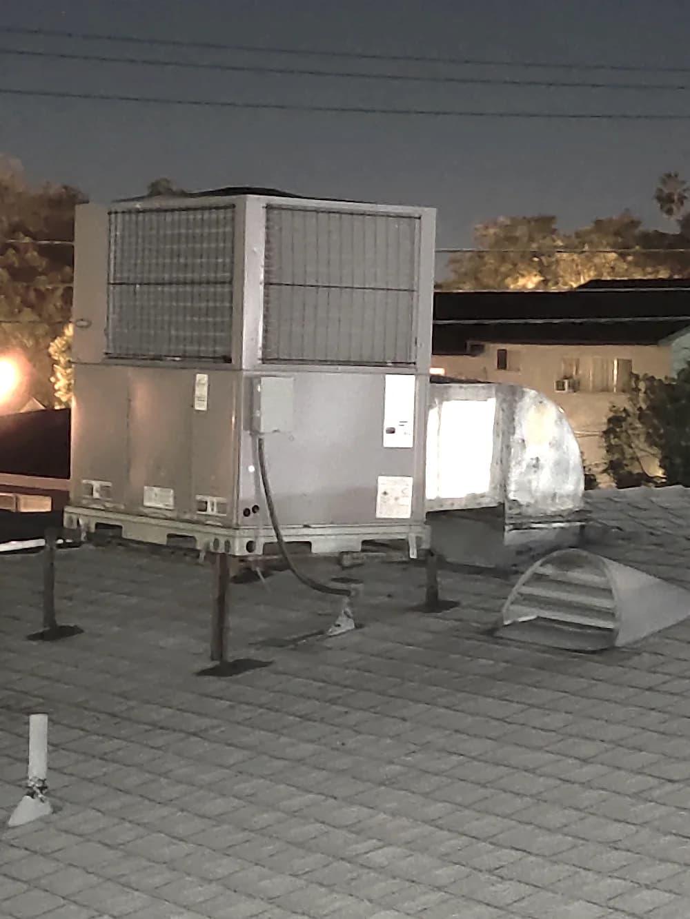 Commercial rooftop HVAC unit and ductwork photographed during an evening service call